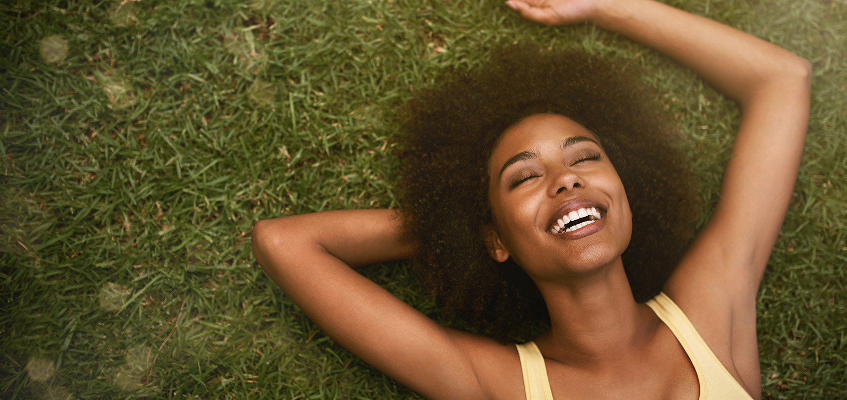 African american woman smiling laying on the grass